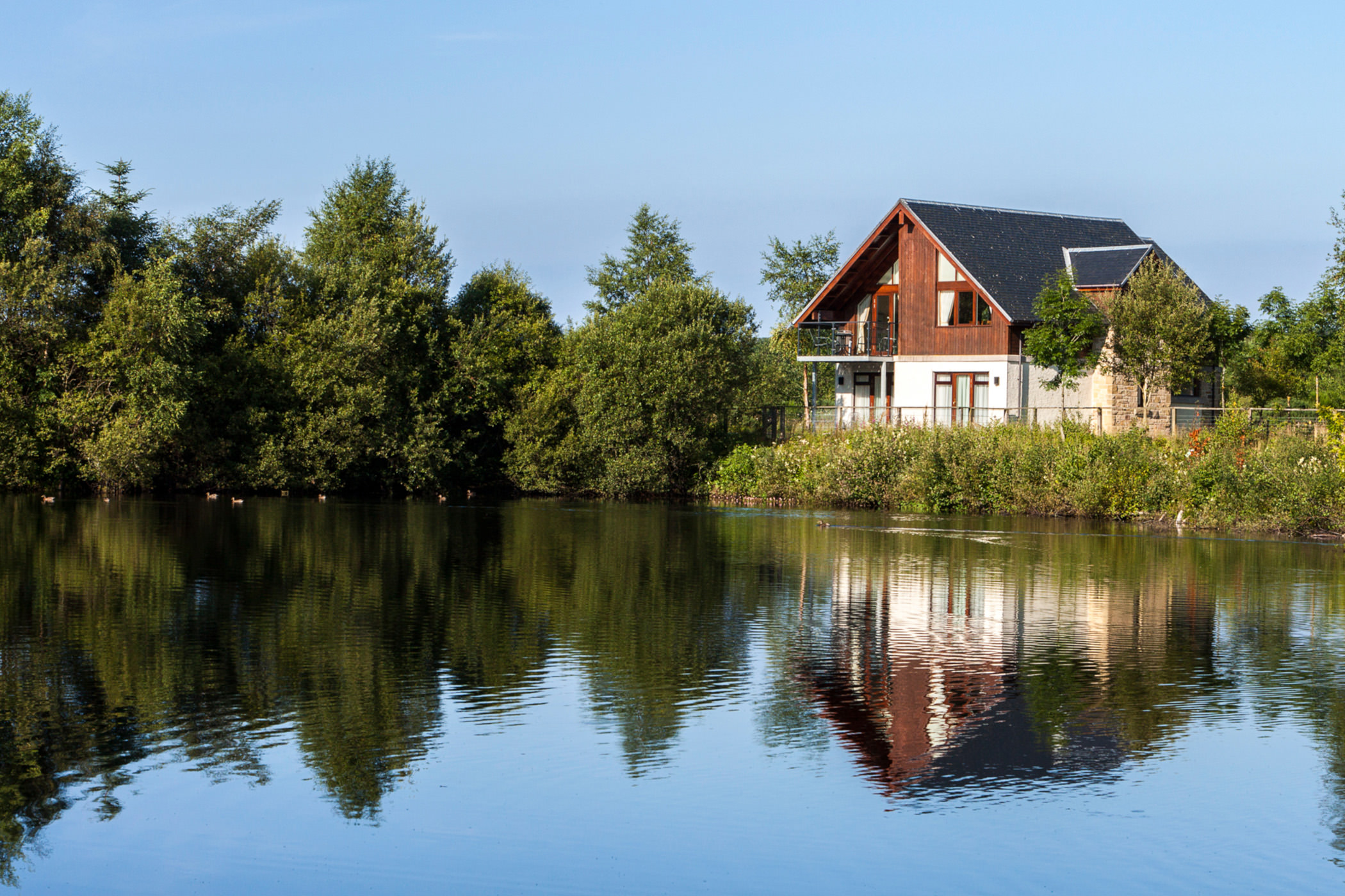 a lodge sitting on the edge of a lake over looking the water