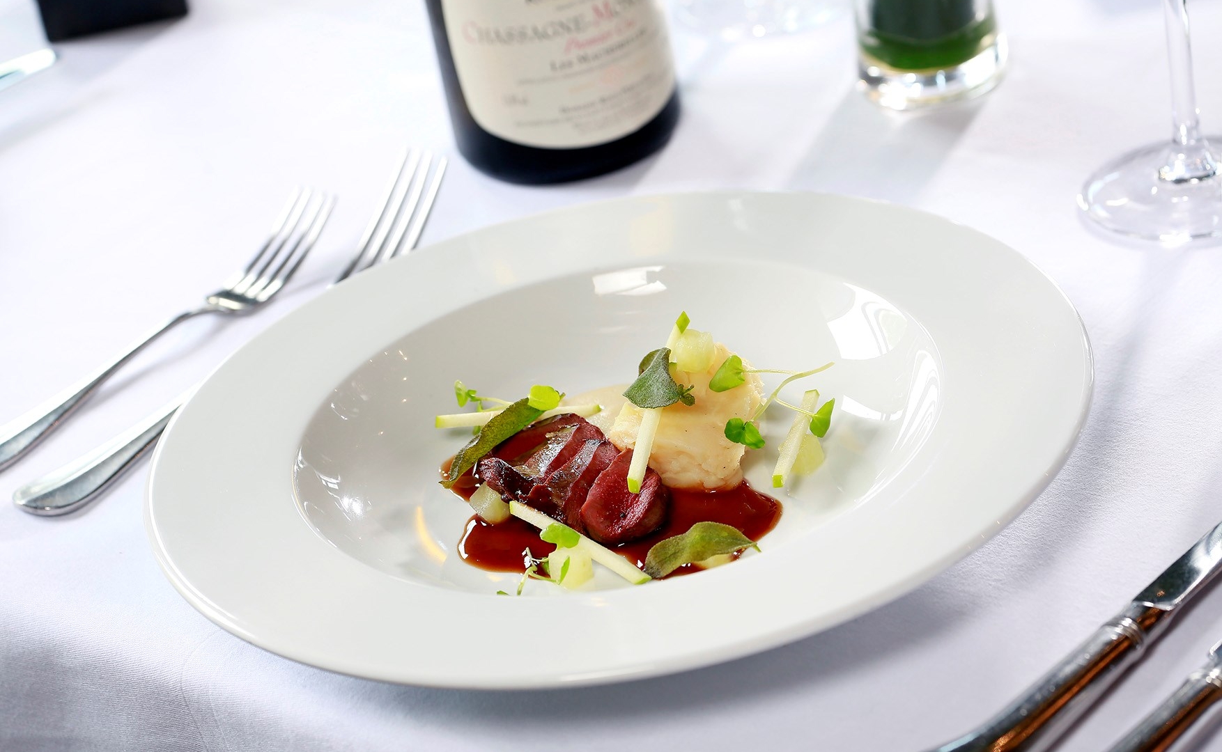 sliced up duck sitting on a plate with colourful garnish