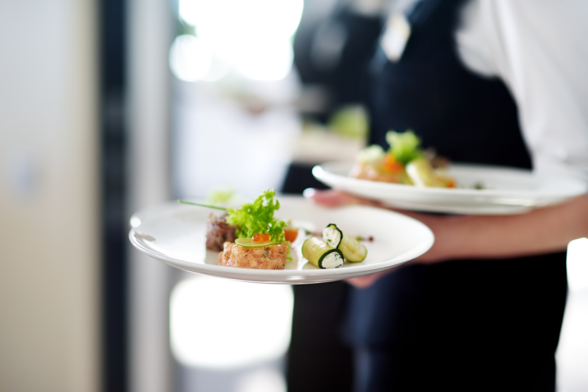 servers carrying plates of food