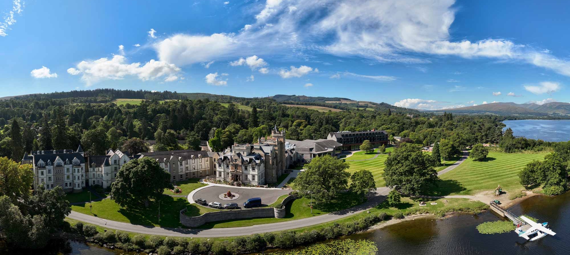 a birds eye view of cameron house showing the water and trees surrounding the property