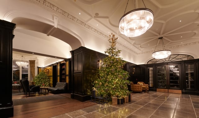 A festive lobby at Cameron House, adorned with a Christmas tree and presents.