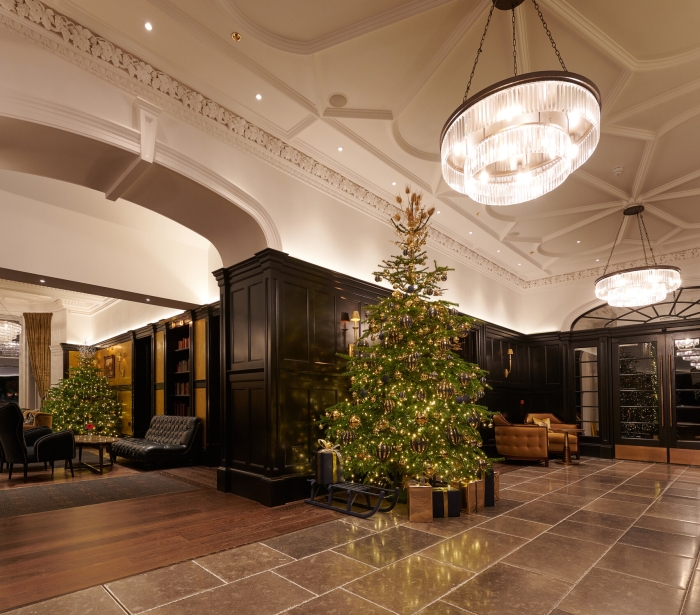 A festive lobby at Cameron House, adorned with a Christmas tree and presents.