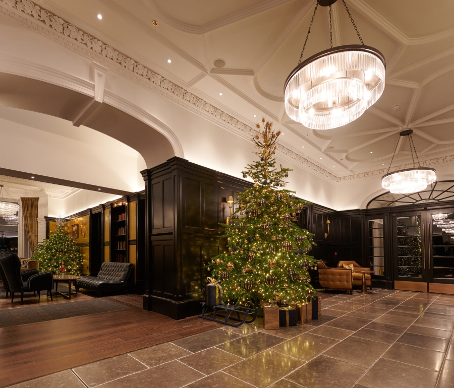 A festive lobby at Cameron House, adorned with a Christmas tree and presents.