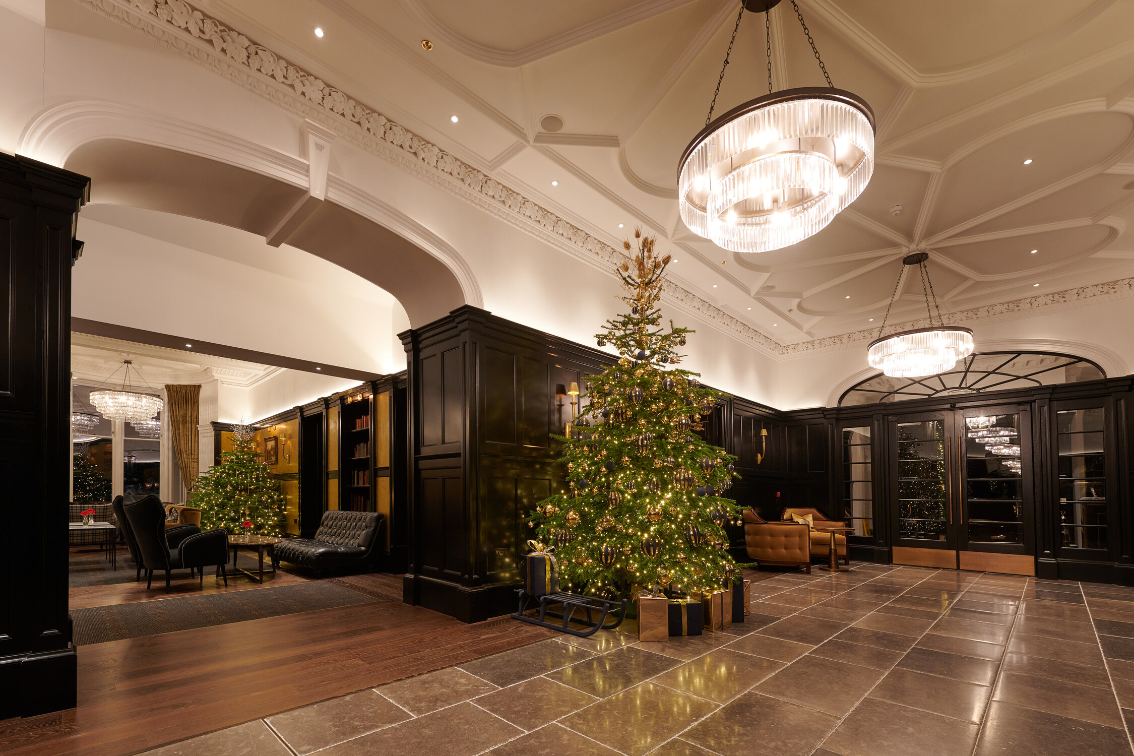 A festive lobby at Cameron House, adorned with a Christmas tree and presents.