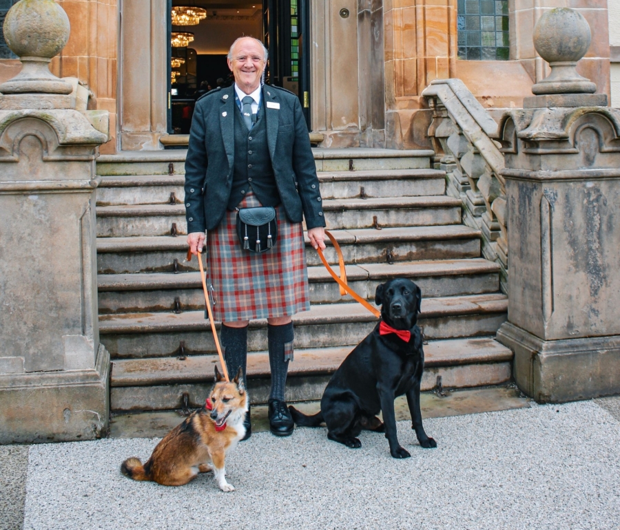 a man smiling for a picture with two dogs