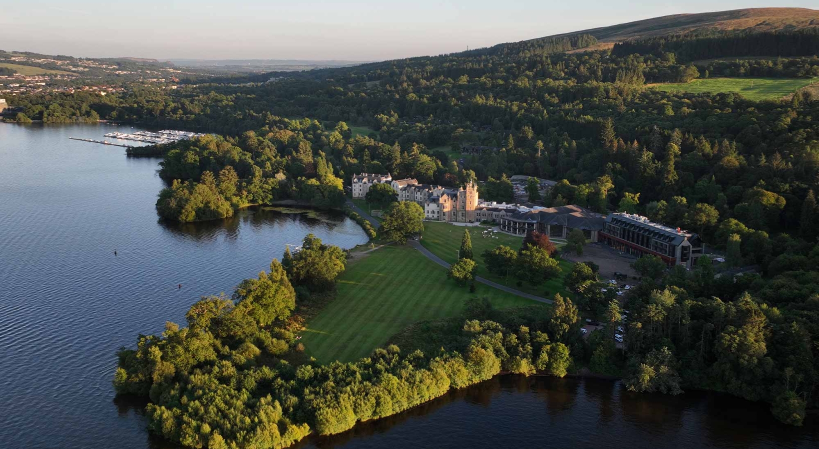 a birds eye view of cameron house with lots of trees and hills behind it