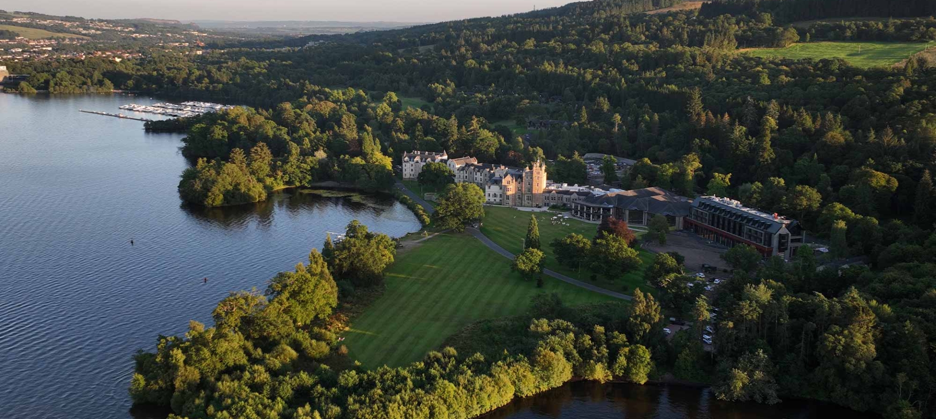 a birds eye view of cameron house with lots of trees and hills behind it