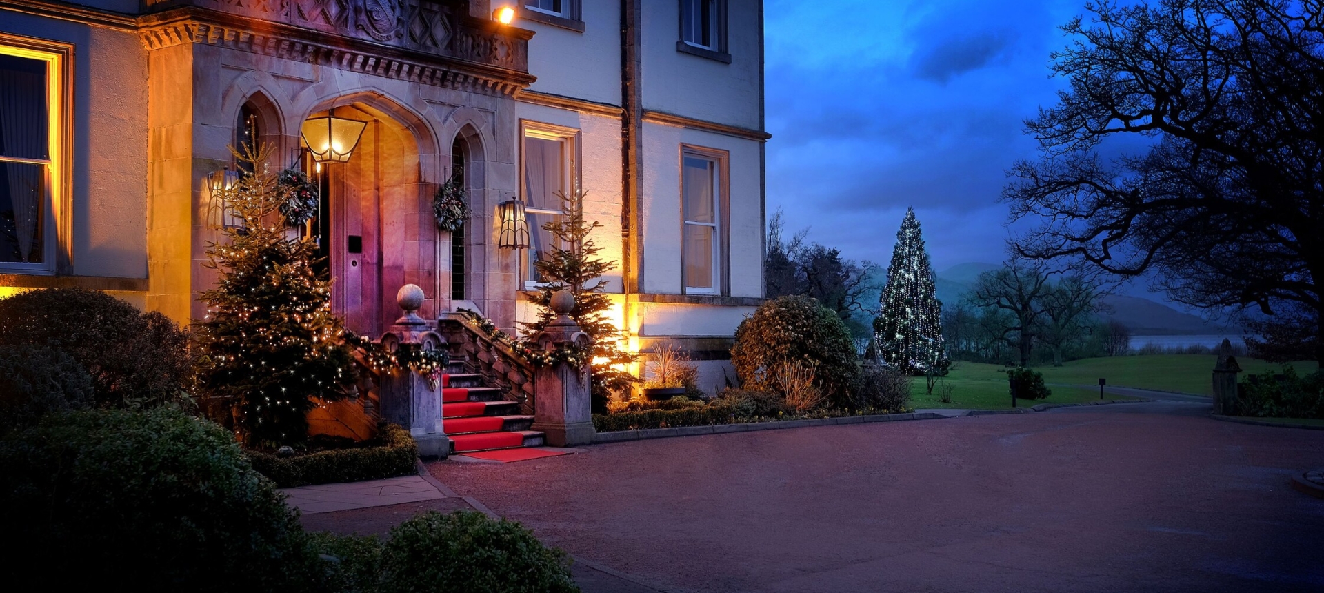 Exterior of Cameron House adorned with twinkling lights on the front steps, creating a festive ambiance for Christmas.