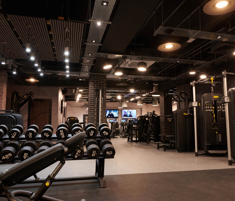 Cameron house indoor gym with weights on a rack and other equipment