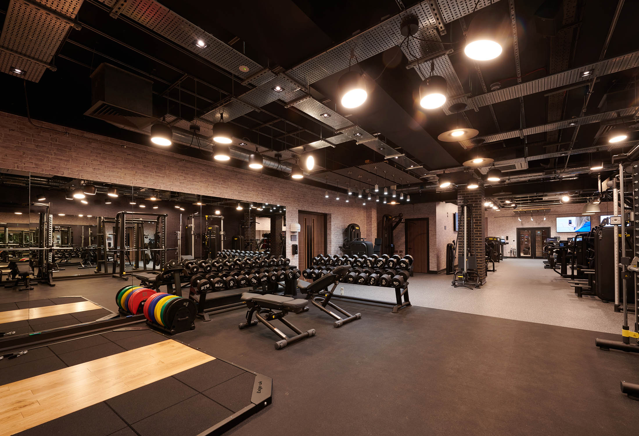 in door gym with weight benches and weight racks in the back