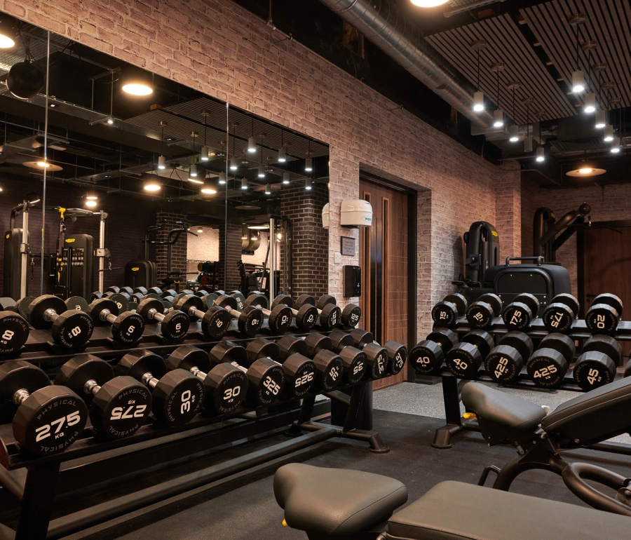 multiple weights sitting on racks along with weight benches