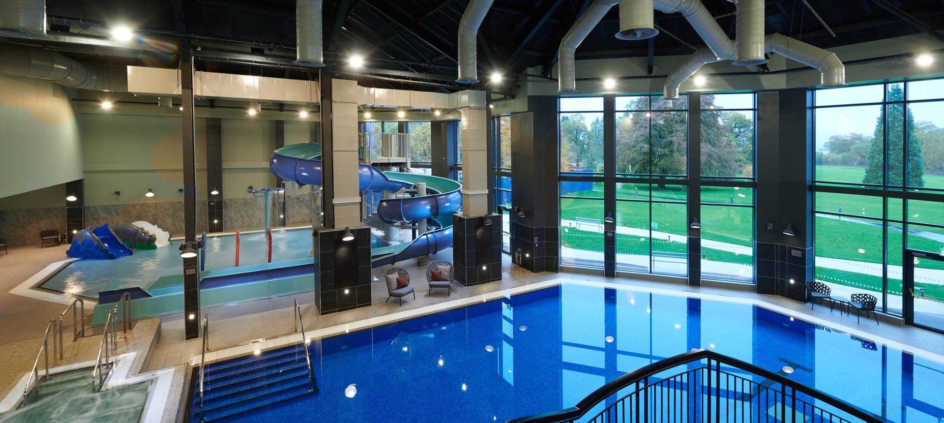 over head view of the indoor pool with large windows showing the trees out side
