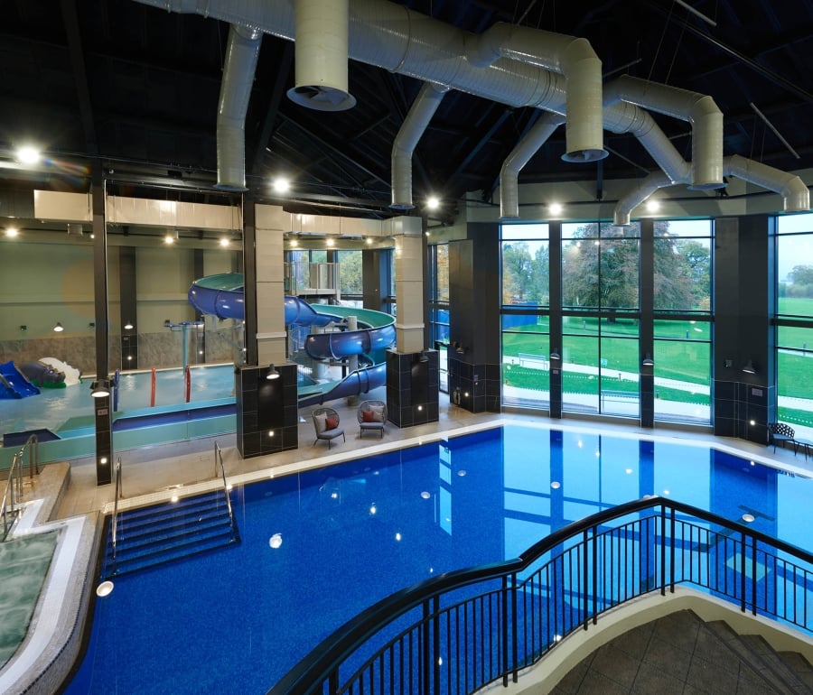 over head view of the indoor pool with large windows showing the trees out side
