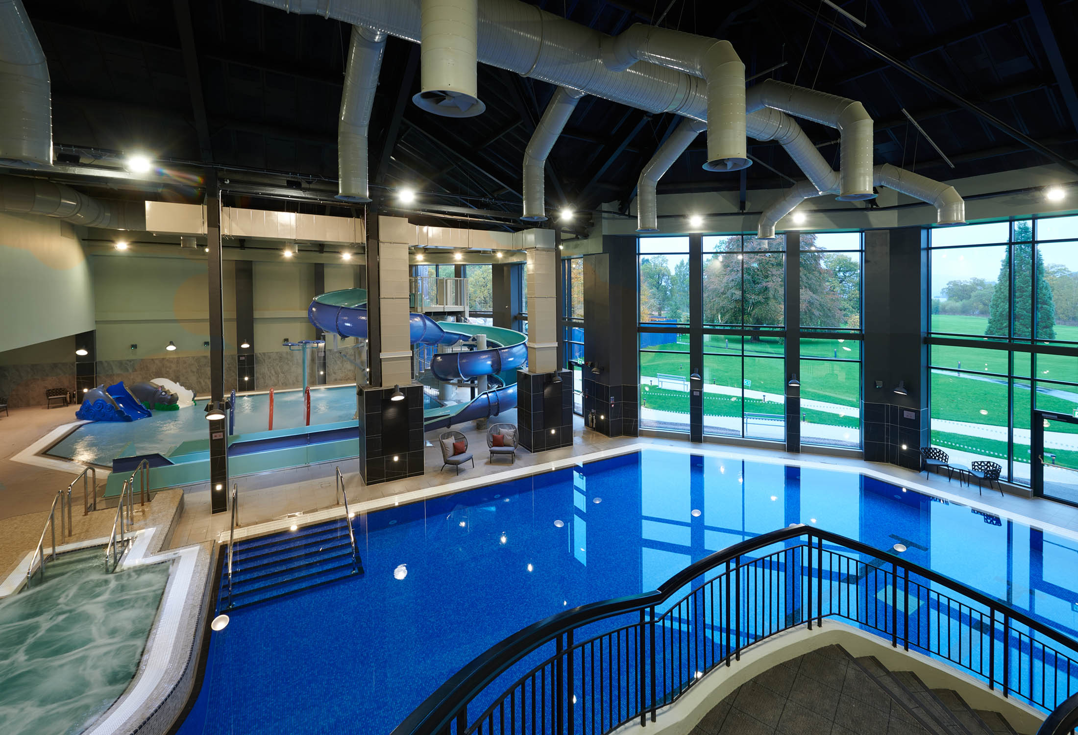 over head view of the indoor pool with large windows showing the trees out side