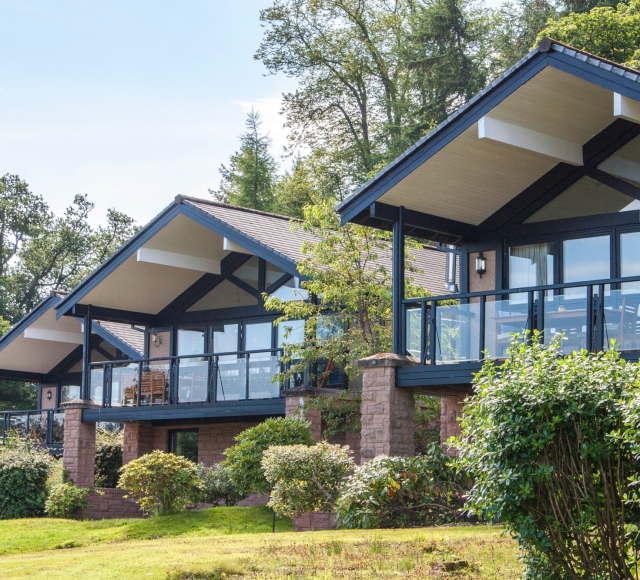 Exterior of the Cameron Lodges with lush green lawns and bushes in the foreground