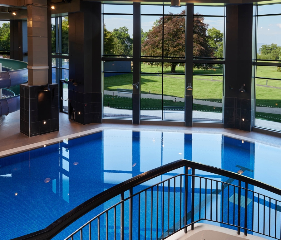 over head view of in door pool with stairs going down to the water