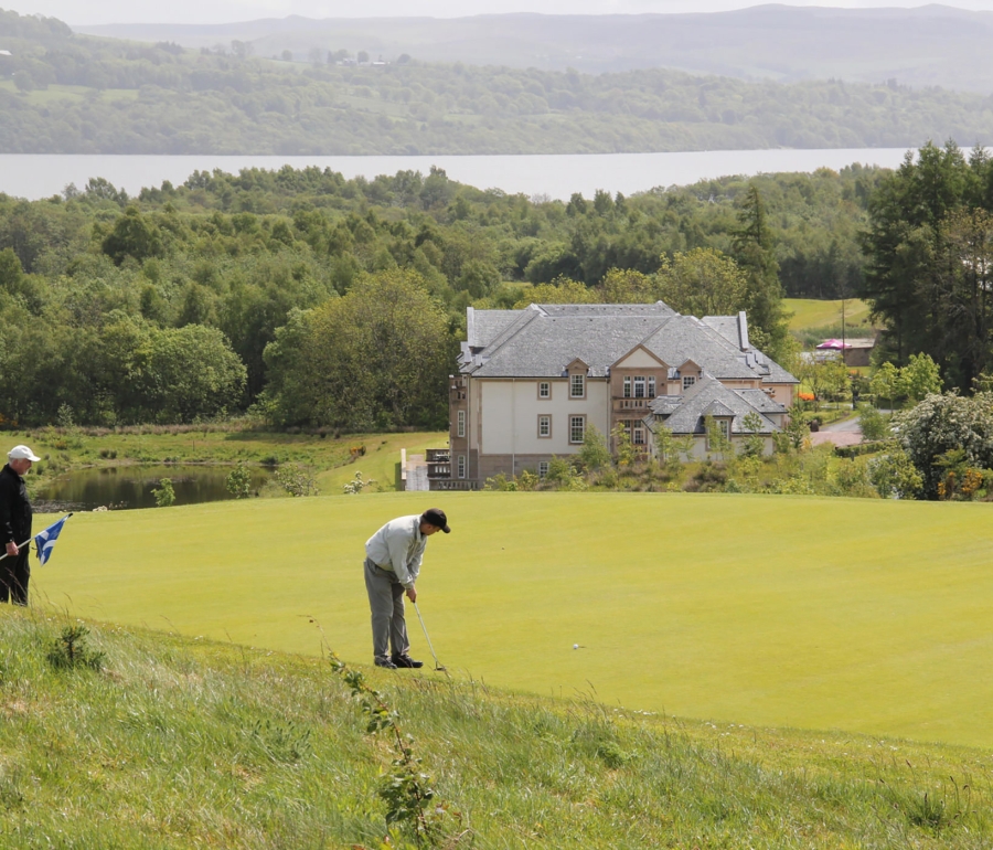 two people playing golf with a large building behind them