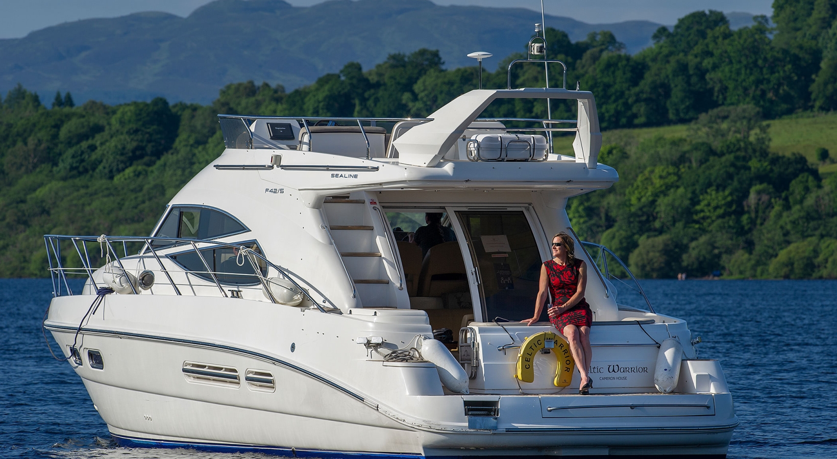 a woman in a dress sitting on a boat in the middle of the water