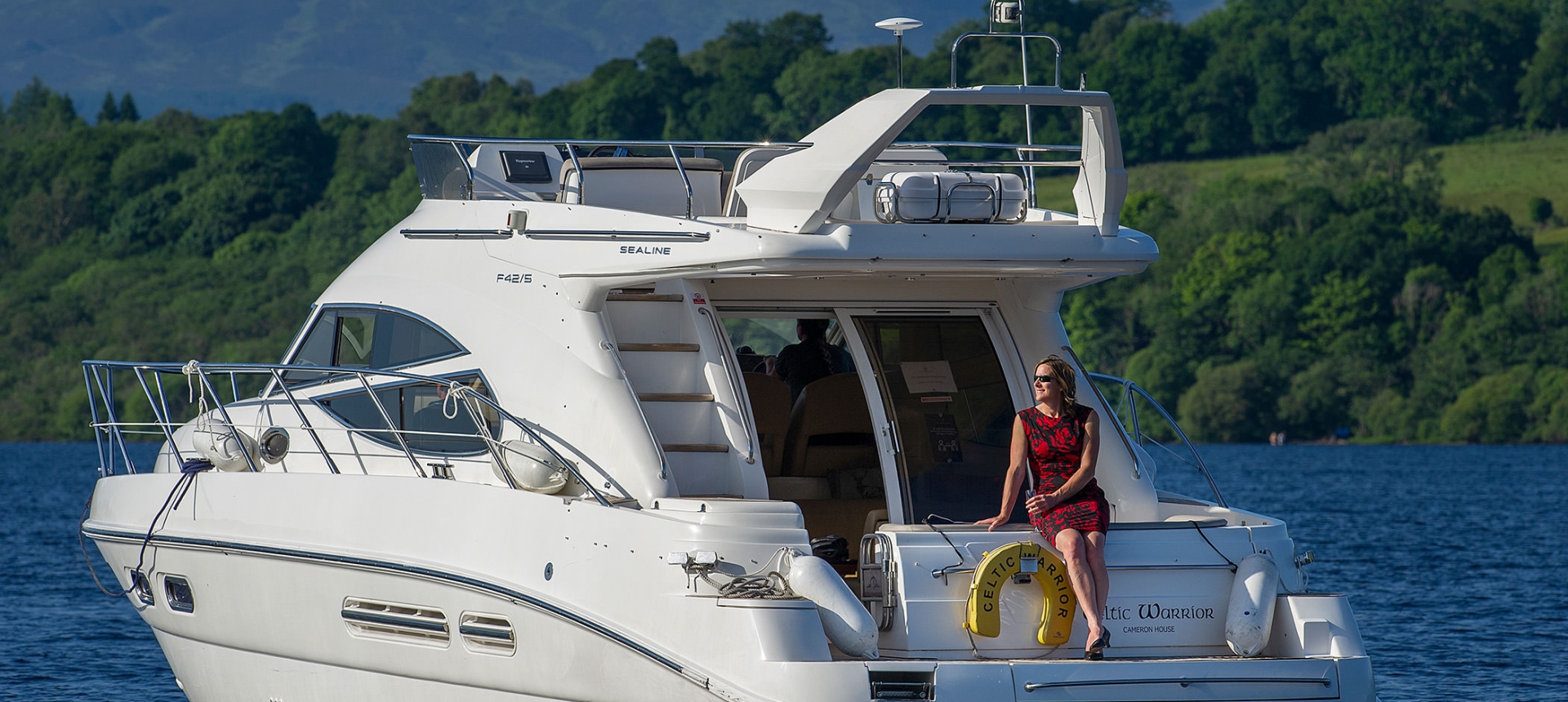 a woman in a dress sitting on a boat in the middle of the water