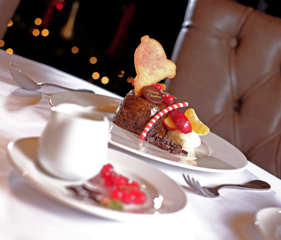 An exquisite Christmas dessert served on a plate and topped with fresh fruit, ready to be savored.