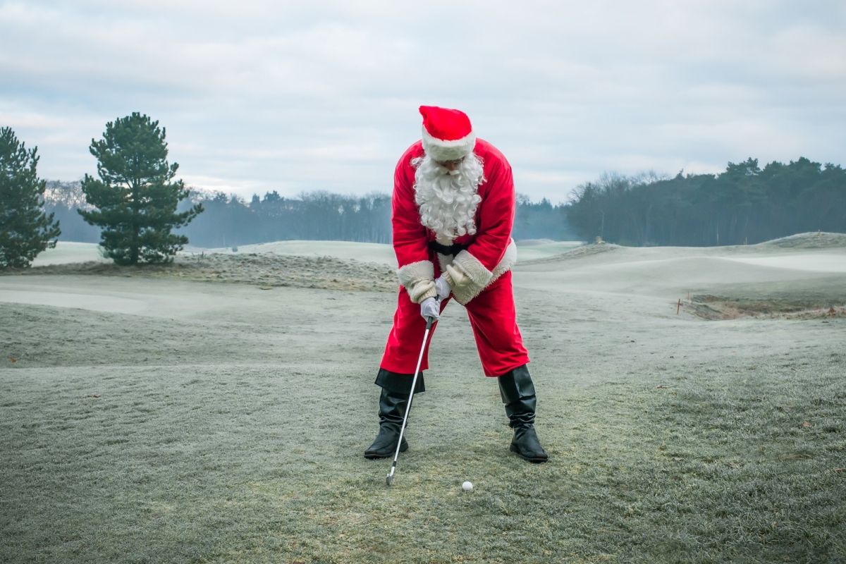 Man in a Santa suit playing golf