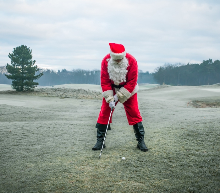 Man in a Santa suit playing golf