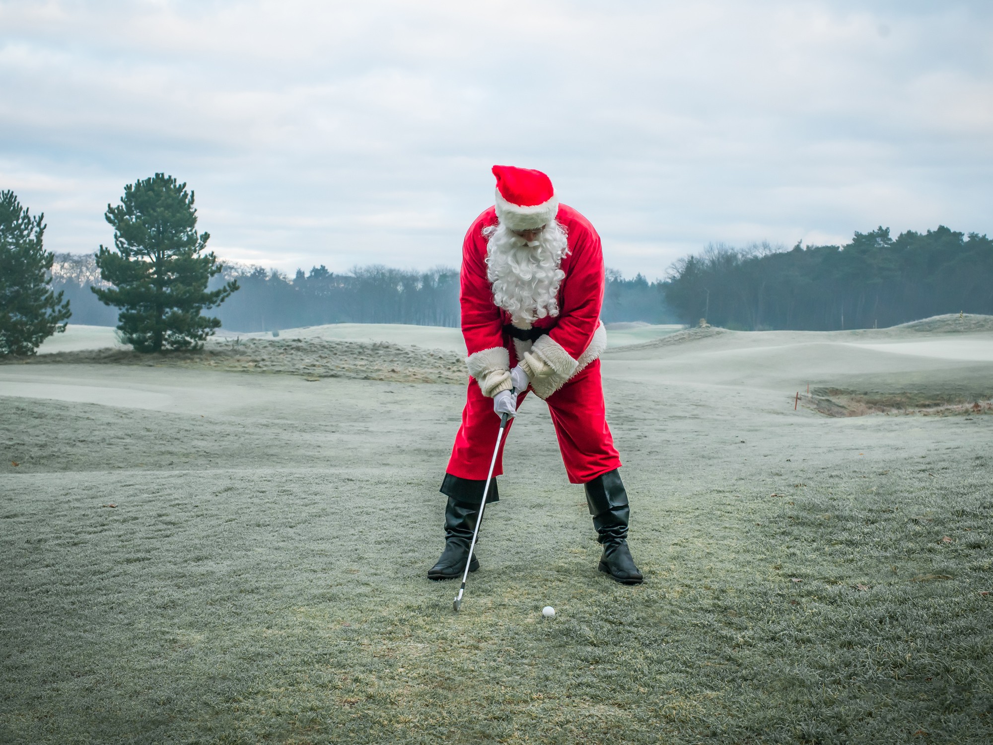 Man in a Santa suit playing golf