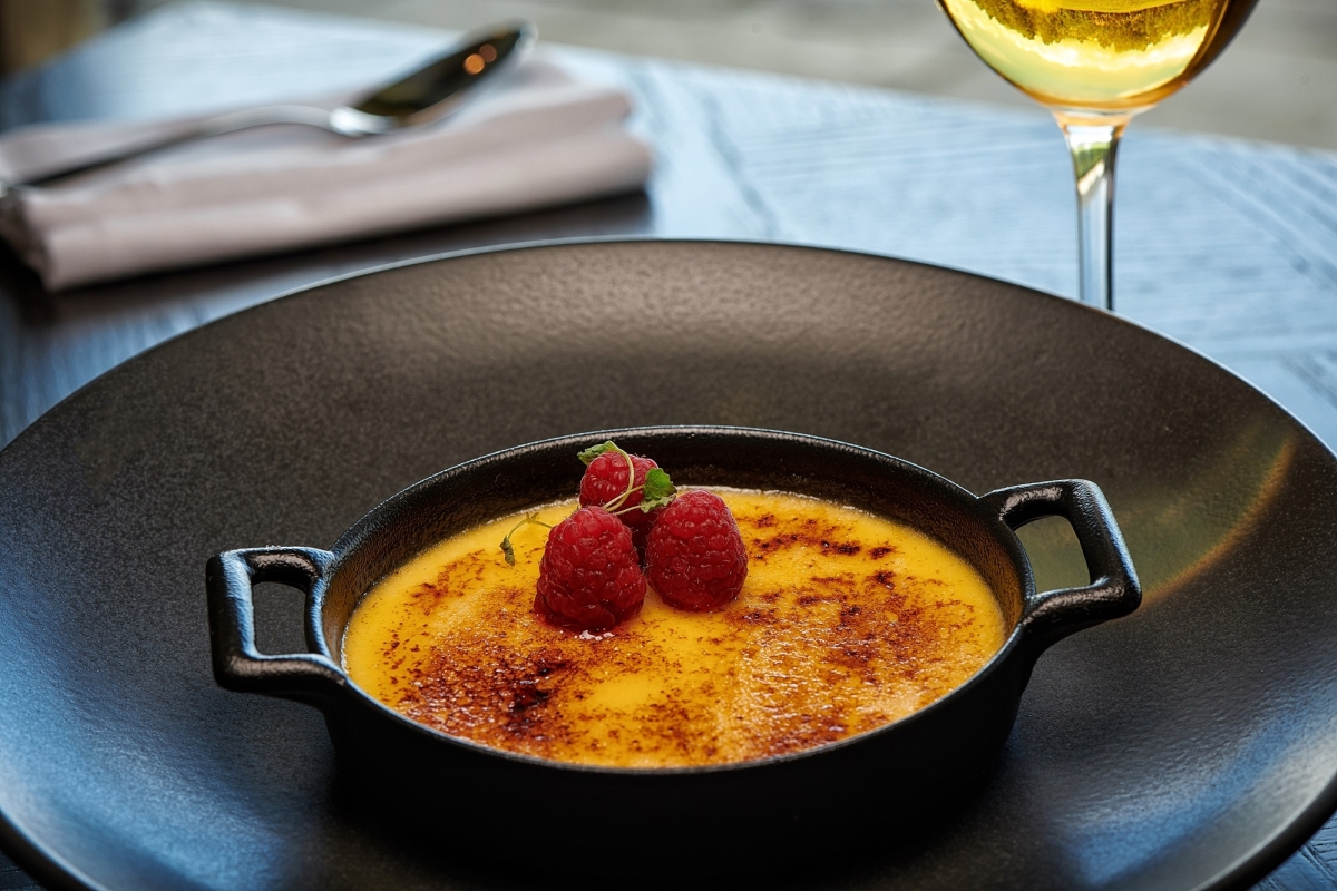 a dessert sitting in a mini pan on a black plate