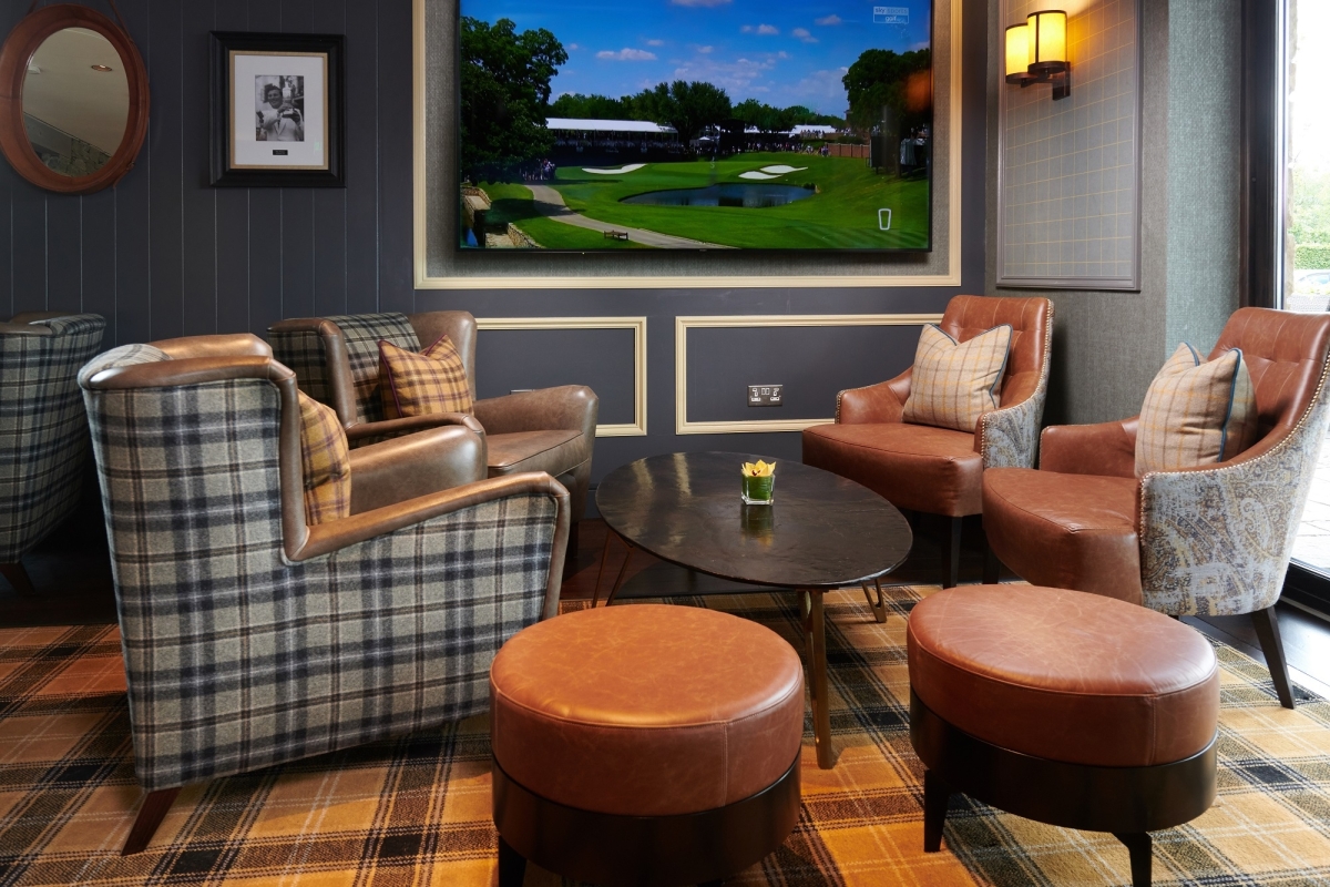 some corner seating in front of a tv playing golf
