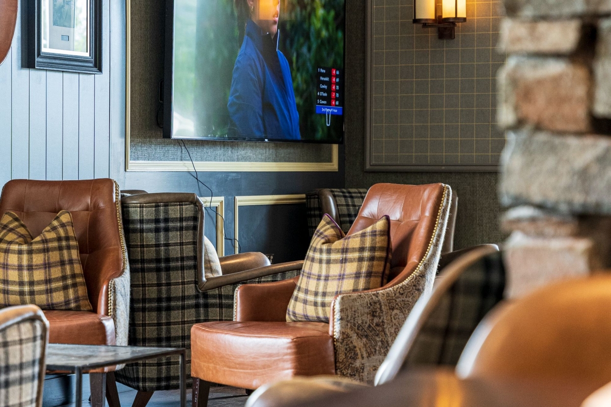 some chairs sitting in front of a tv playing golf