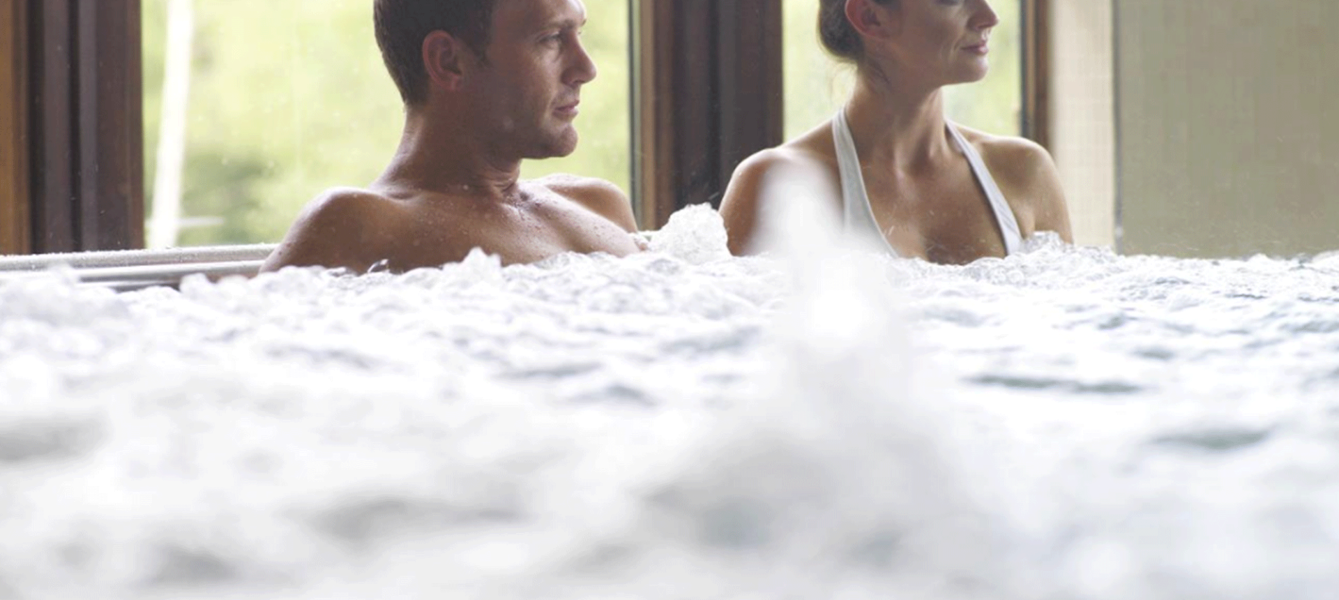 a man and woman sitting in a hot tub with the jets going