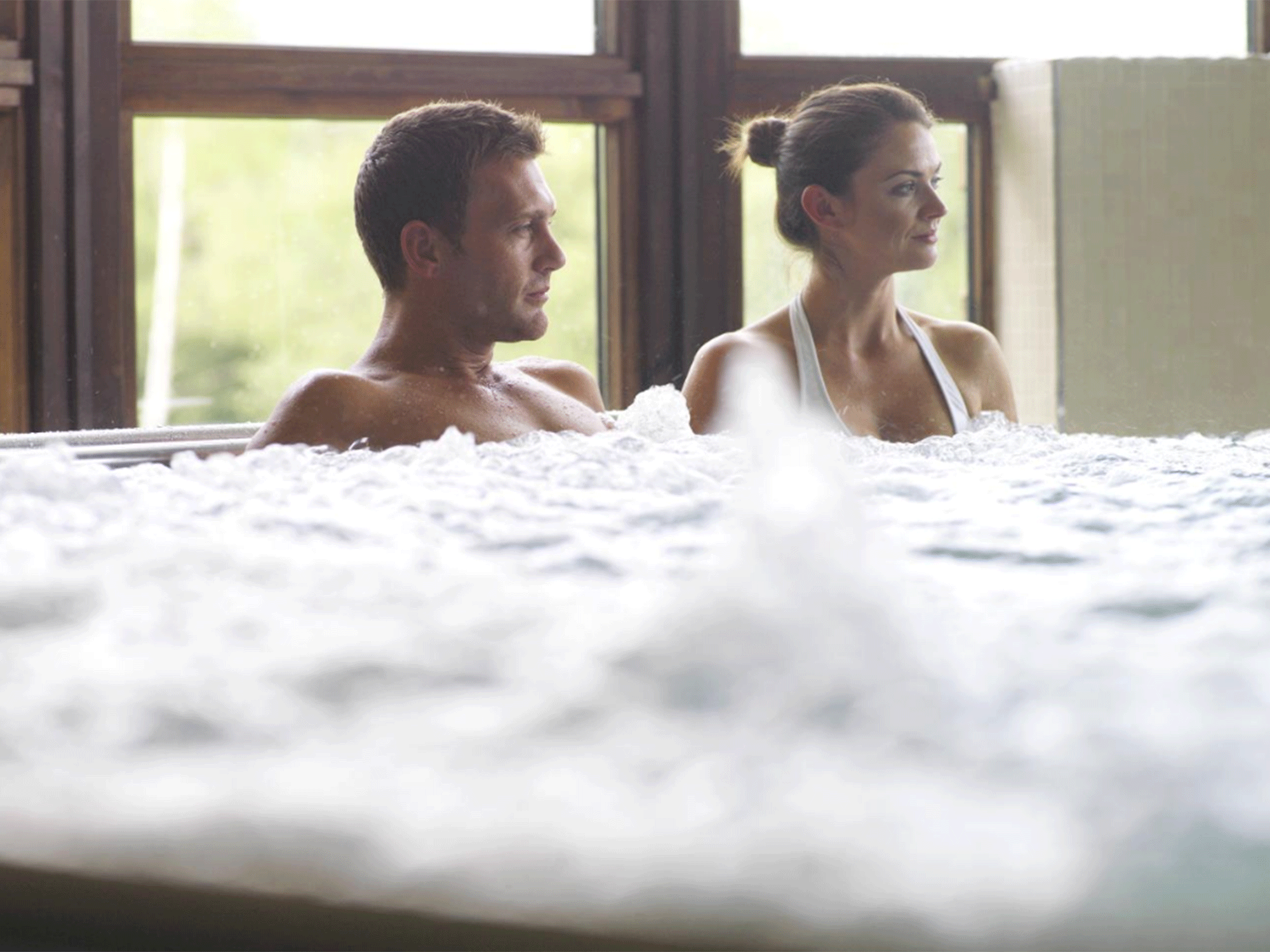 a man and woman sitting in a hot tub with the jets going