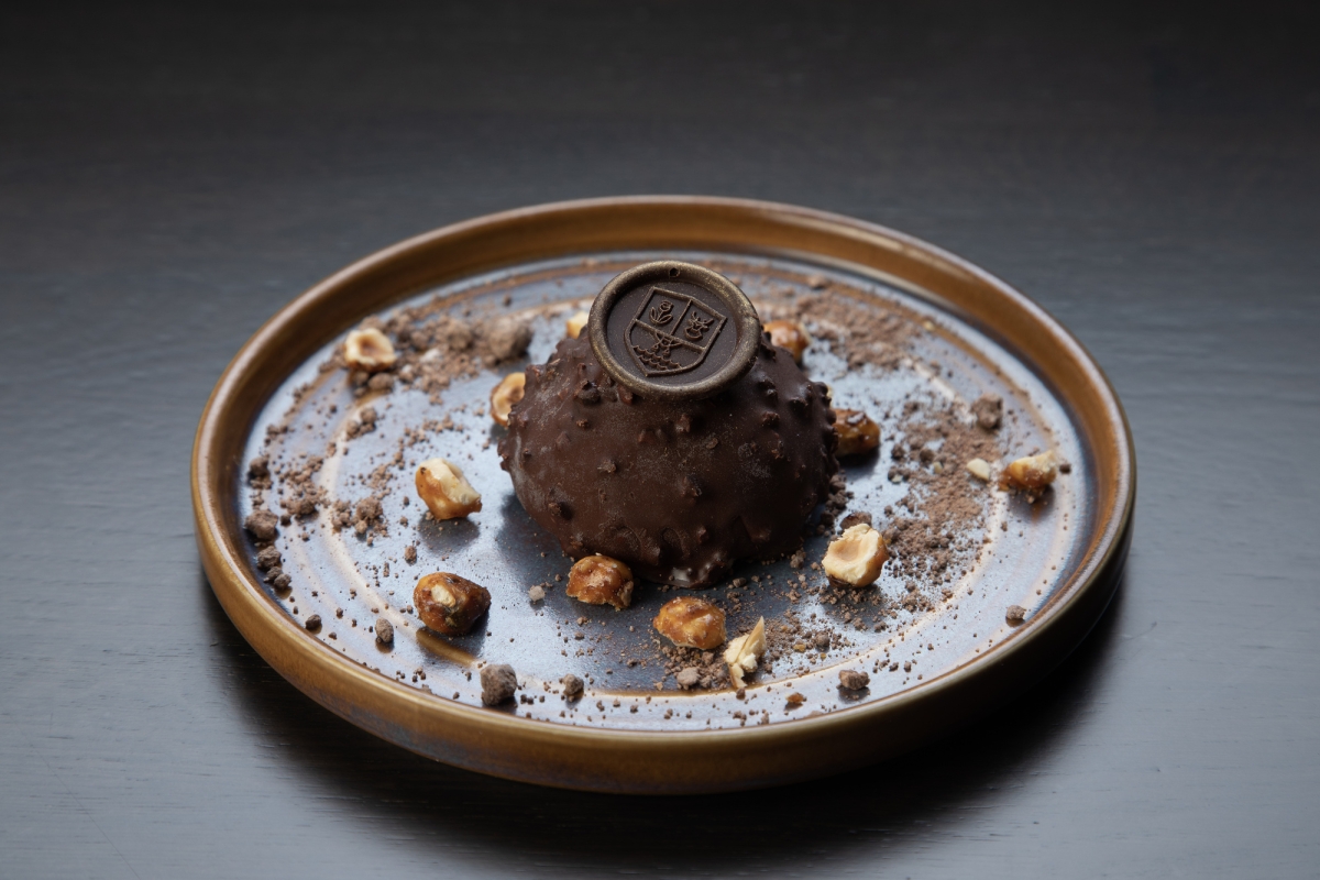 Chocolate dessert with nuts and a monogramed chocolate on a plate from La Vista restaurant.