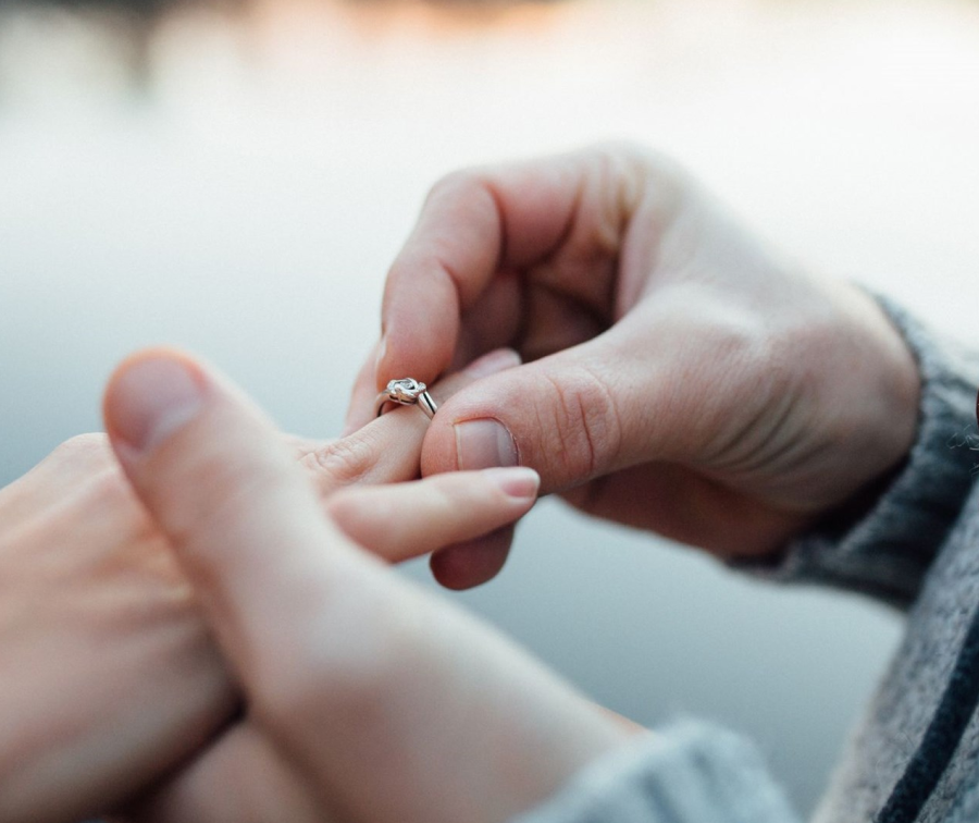 a groom putting a wedding ring on his bride