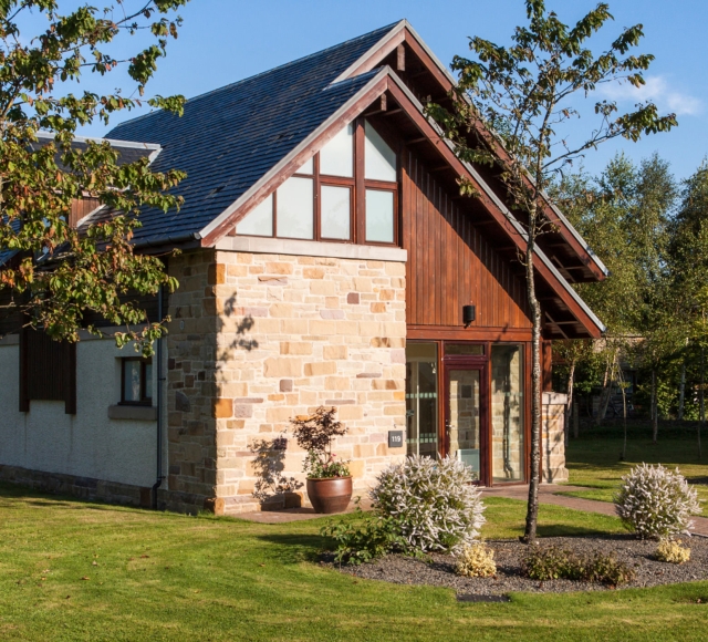 a lodge with a beautiful front yard and gadren