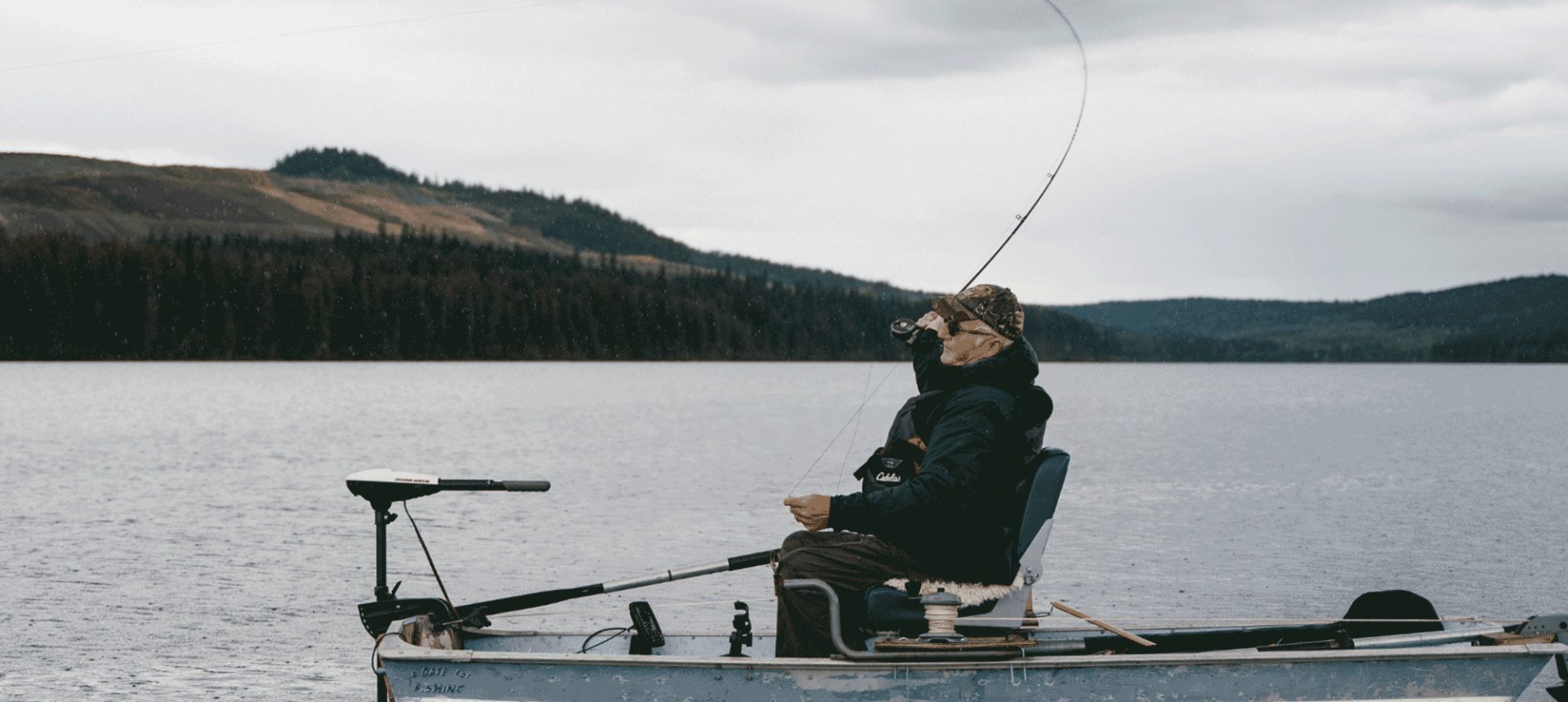 a old man sitting on a boat fishing in the middle of the water