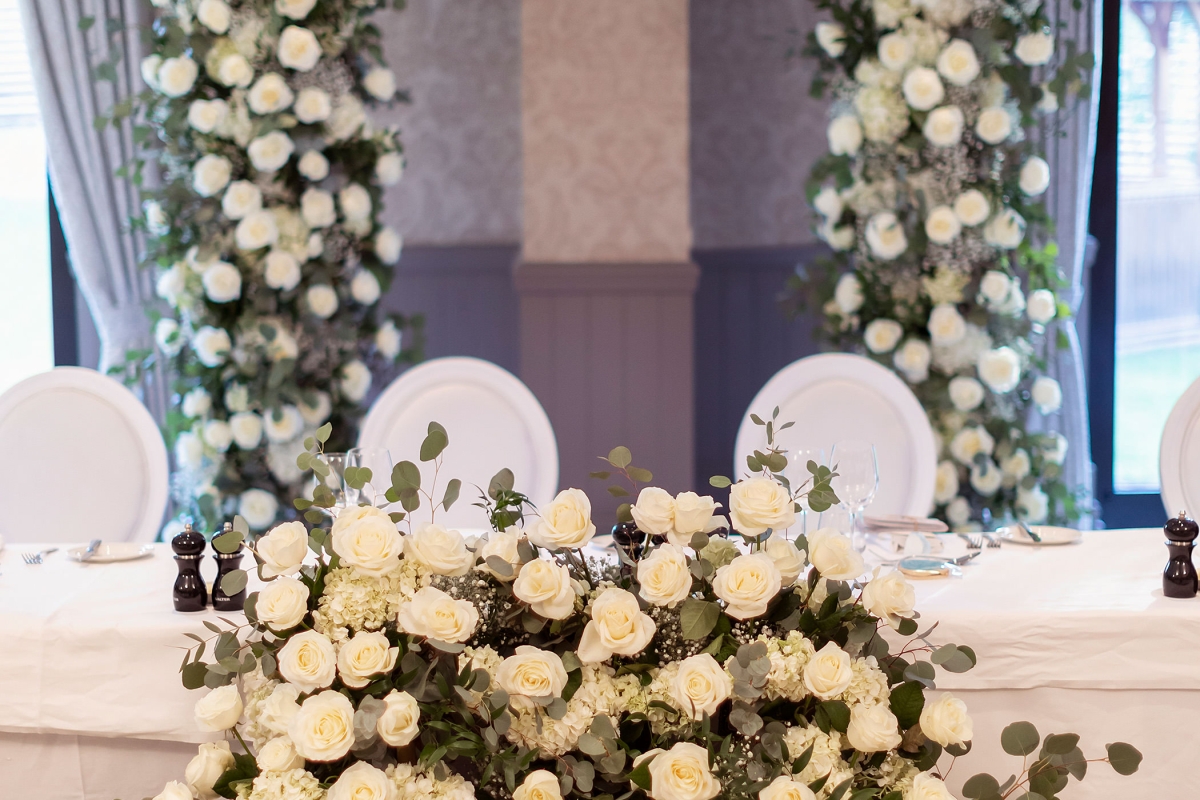a large floral arrangement of beautiful white flowers set up for a wedding reception