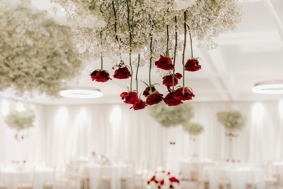 a large room with checkered flooring and tables with roses dangling above them