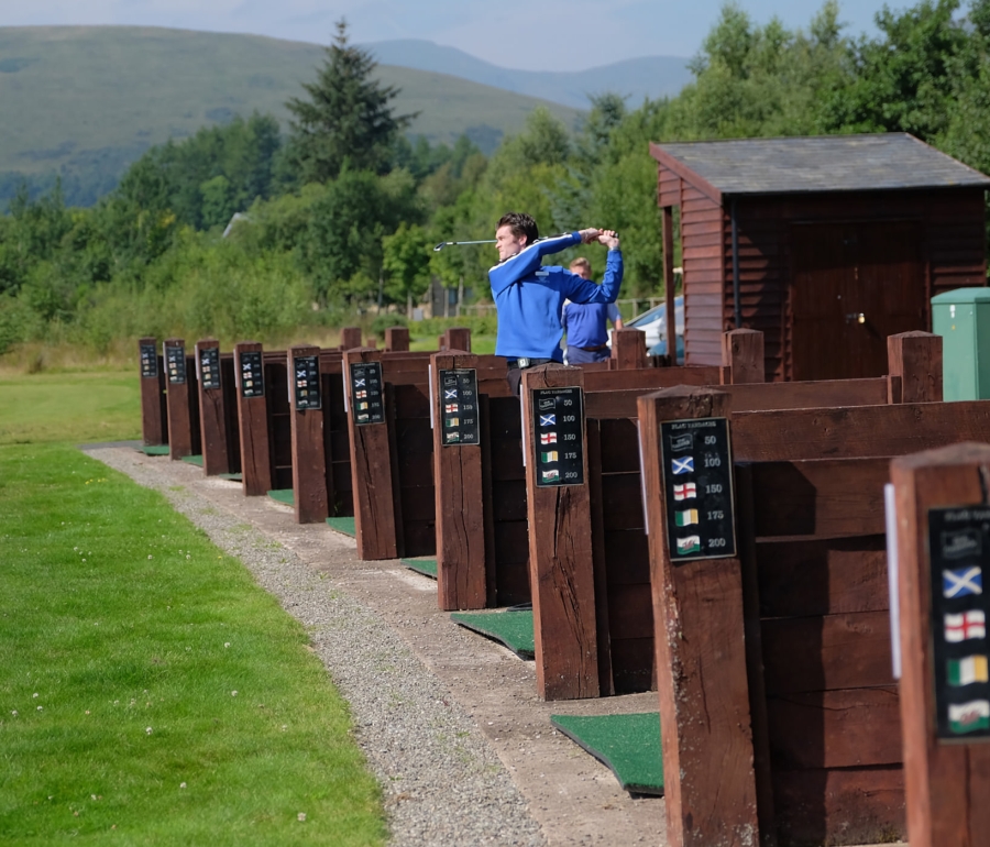 a man practicing his golf swing at a out door driving range