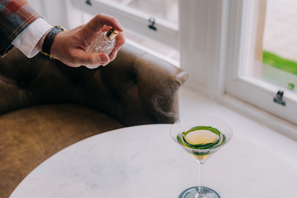 someone spraying flavour spritz on a cocktail