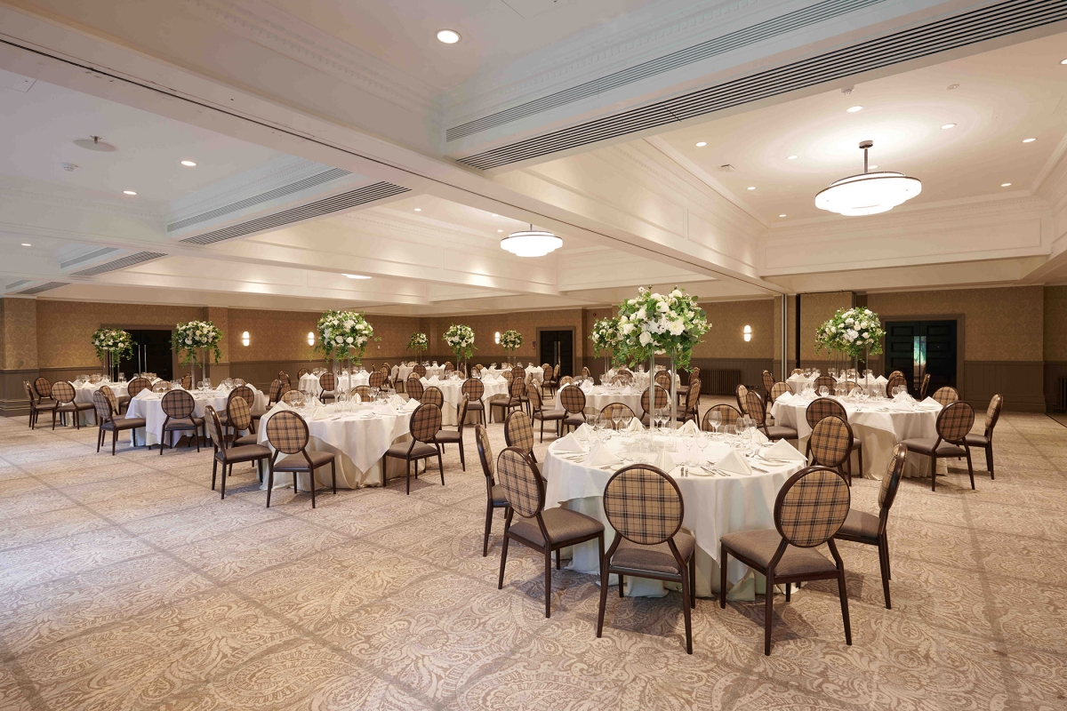 banquet setup providing lots of seating at white round tables in a open meeting area