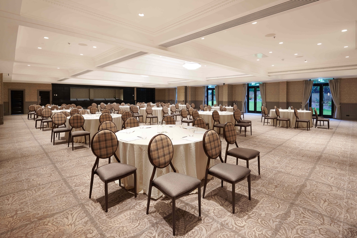 Elegant event space located inside Cameron House with lots of seating and silverware on the tables