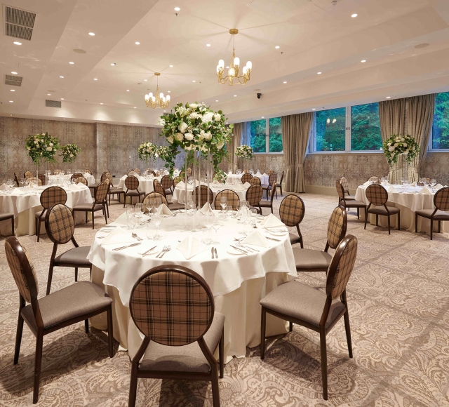 banquet setup with tables and chairs along with windows looking outside