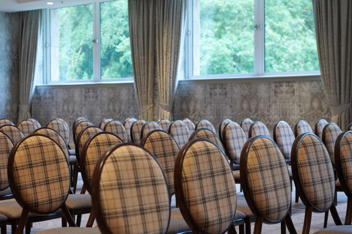 Seating inside an event room showing off the green trees outside