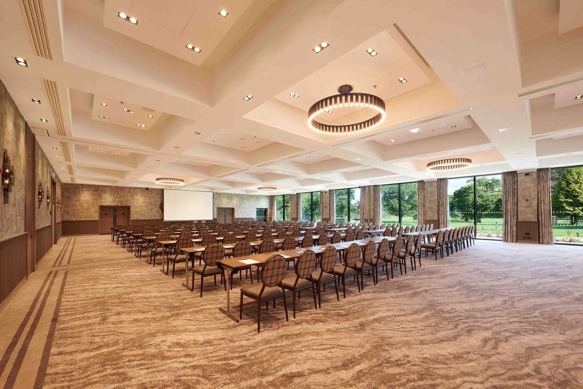 meeting room set up with rows of tables and chairs along with great outside views and lots of natural lighting