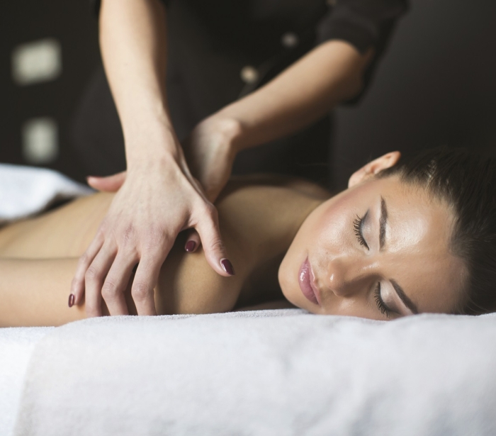 a woman laying on a table getting her shoulder massaged