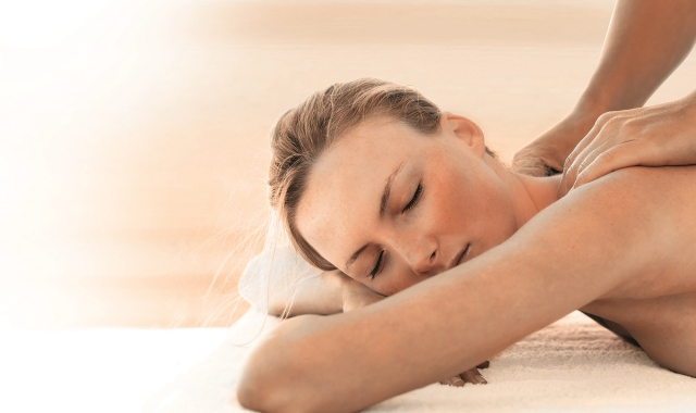 a woman getting her shoulders massaged in a spa