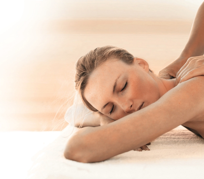 a woman getting her shoulders massaged in a spa