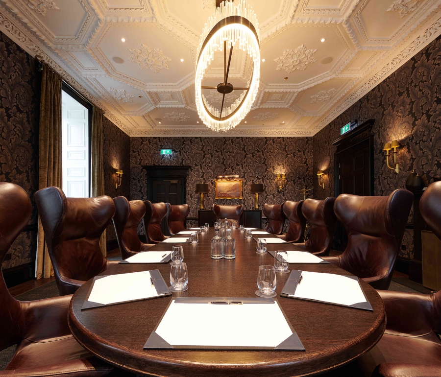conference meeting space with a large round table and many brown leather chairs