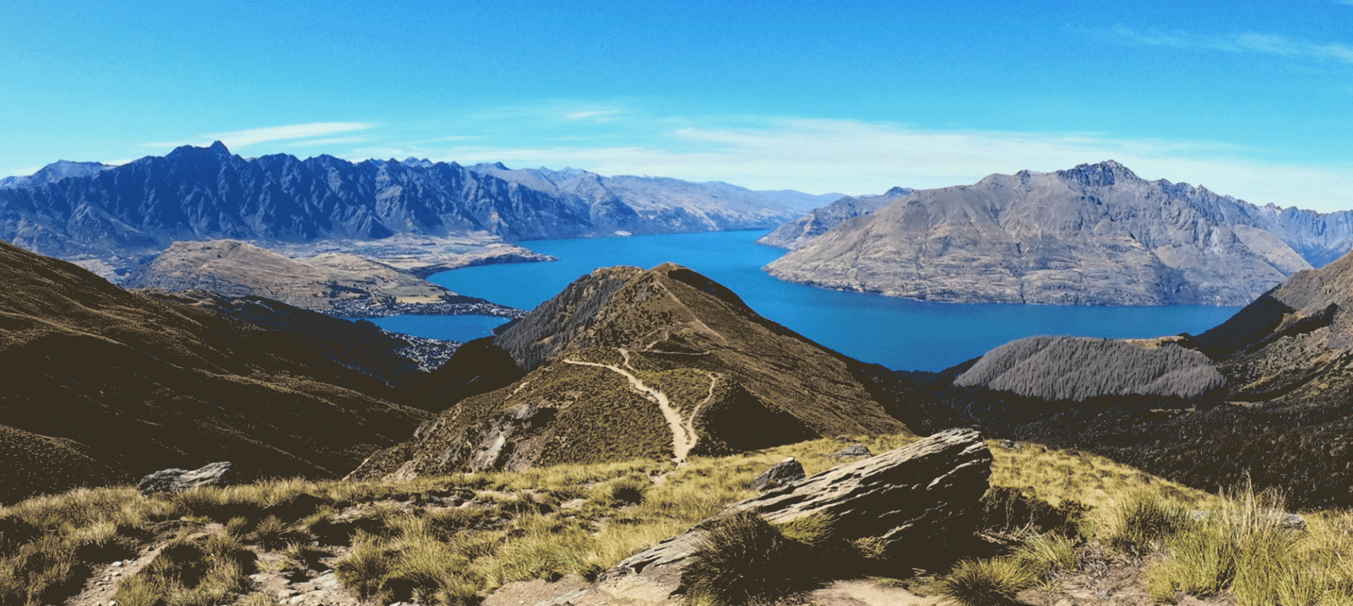 large mountains overlooking a body of water on a sunny day